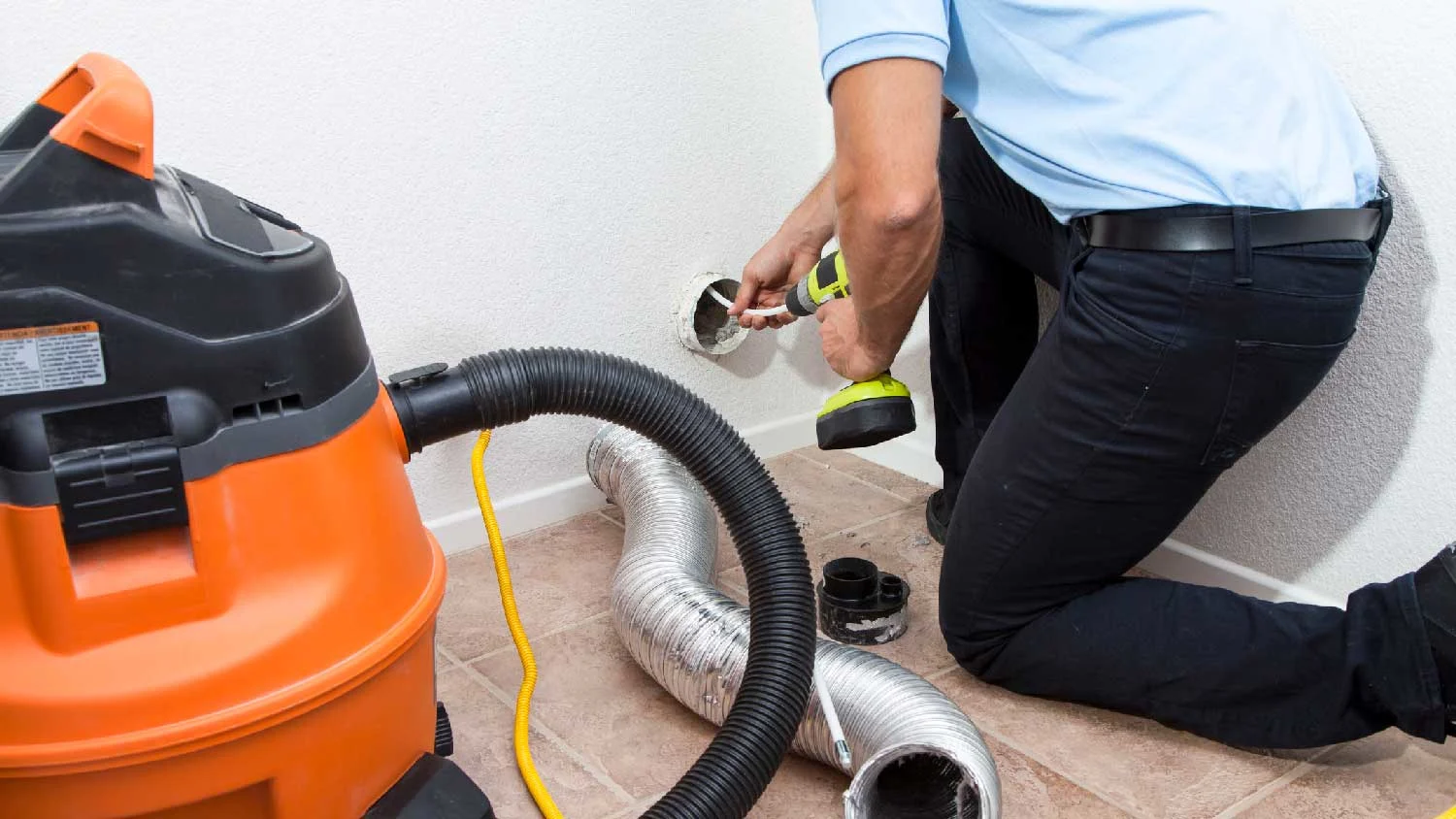 Technician cleaning lint from a dryer vent
